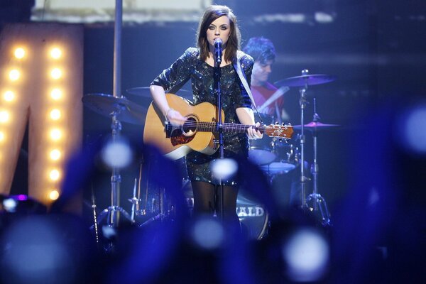 Amy Macdonald gra na gitarze i śpiewa na koncercie