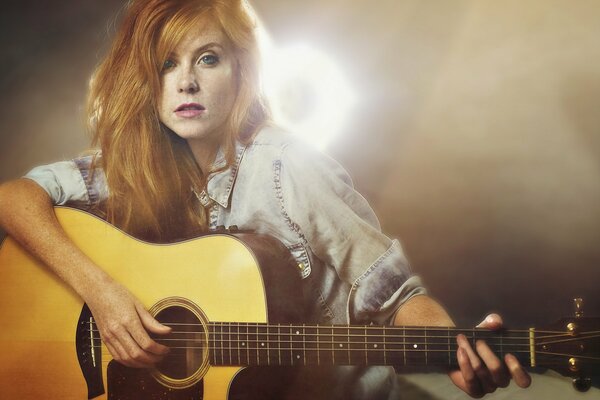 A girl plays a song on the guitar