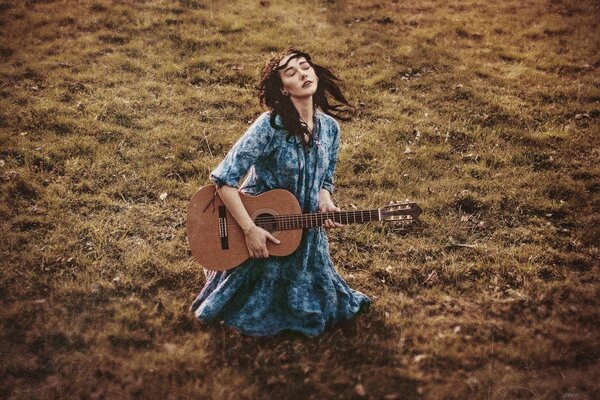 Fille avec une guitare sur l herbe