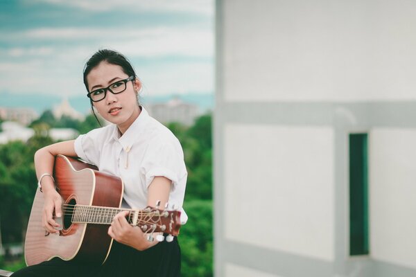 Mädchen mit Brille mit Gitarre