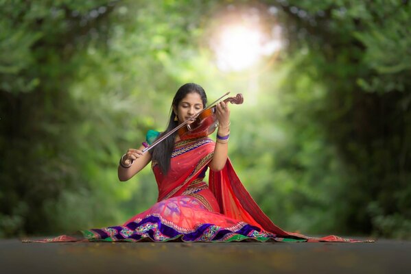 A girl in a sari plays the violin