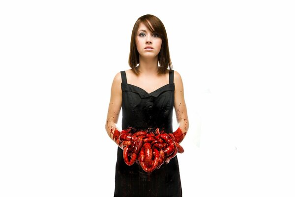 A girl in a black dress holds guts in her hands