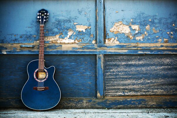 Niebieska gitara na tle obskurnej ściany