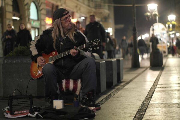 Uliczny muzyk gra na gitarze