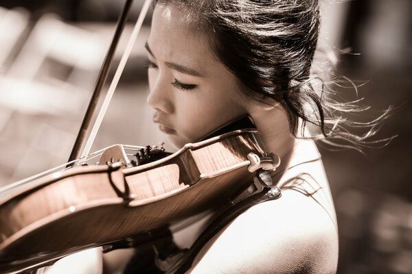 A young girl plays the violin