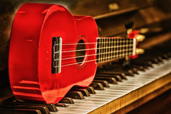Die Gitarre liegt auf dem Klavier und spielt rote Musik