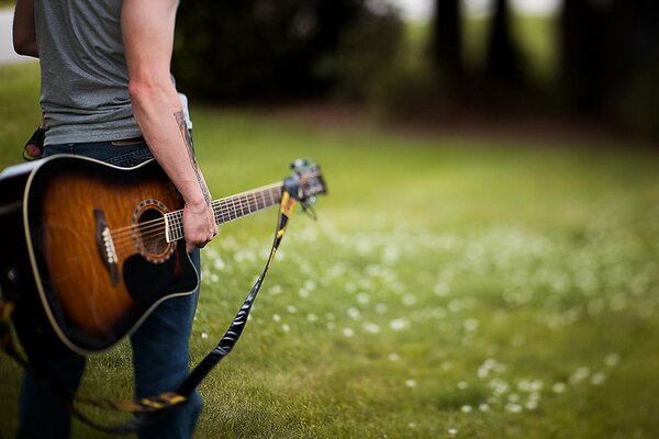 Ein Mann in Jeans mit einer Gitarre in der Hand