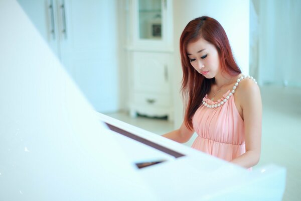 A beautiful woman plays classical music on the piano