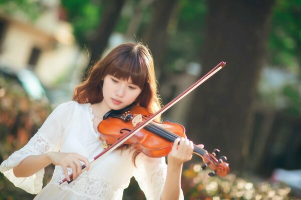 A girl in white plays the violin
