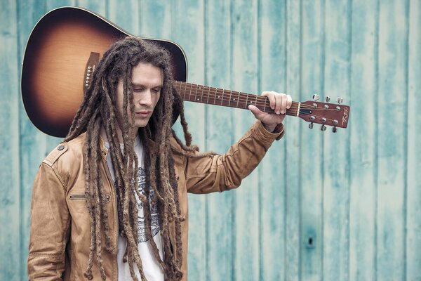 Junger Mann mit Gitarre auf der Schulter