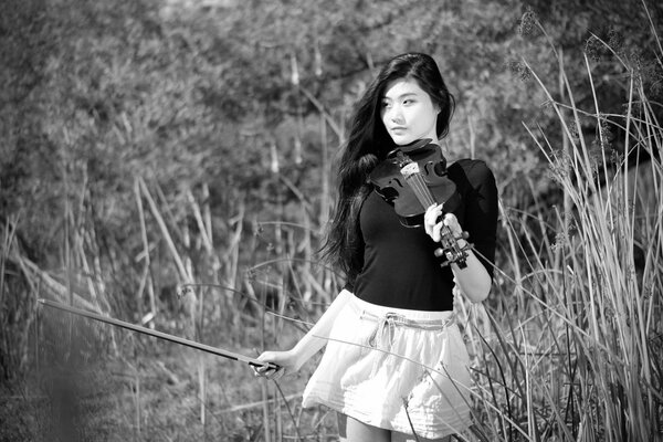 Chica con violín sobre fondo blanco y negro