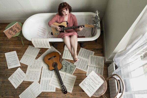 Mädchen spielt Gitarre im Badezimmer