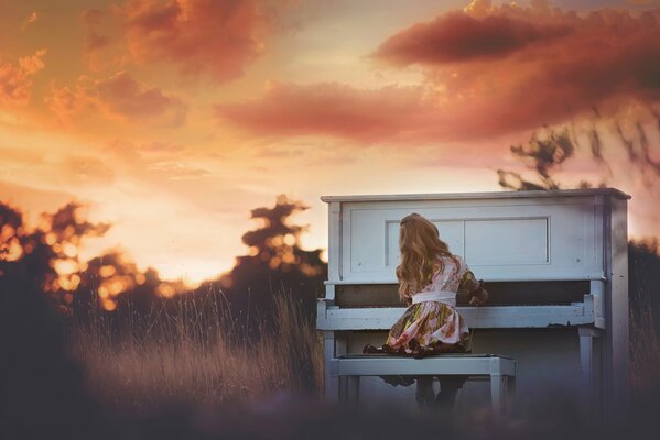 Fille jouant au coucher du soleil sur le piano