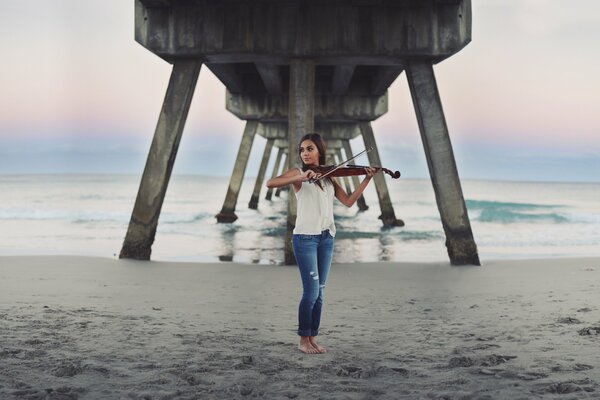 Fille au bord de la mer joue du violon