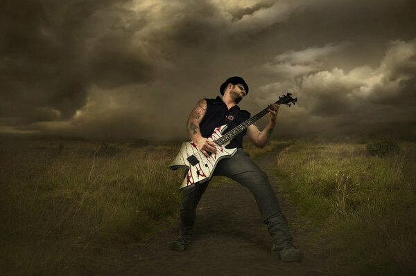 A rock musician with a guitar on the background of thunderclouds