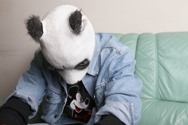 Die Panda-Maske trägt einen Mann mit einer Jeansjacke