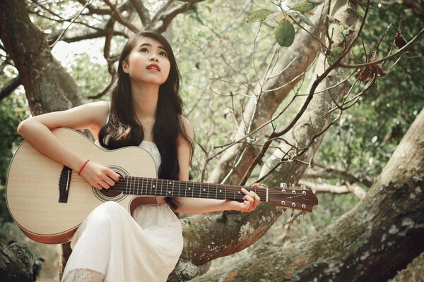 Asian girl playing guitar