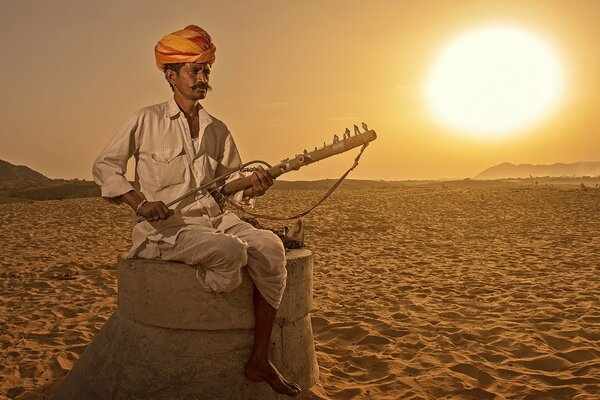 Ein Mann aus Indien hält ein Musikinstrument