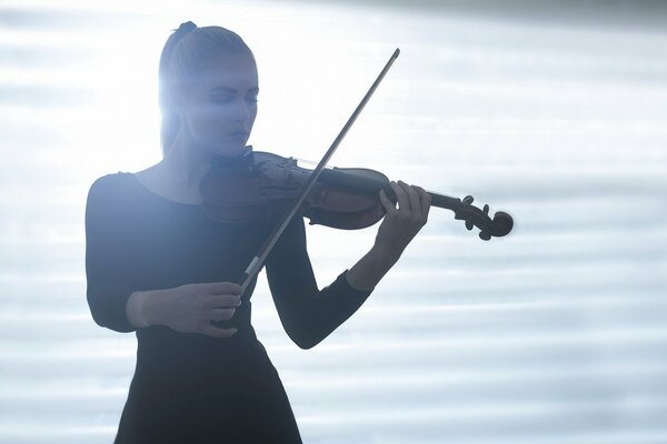 Fille jouant du violon dans la lumière