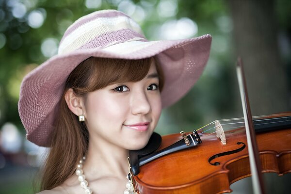 A girl in a hat with a violin is playing