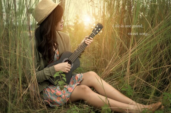 Guitar in the hands of a girl in nature