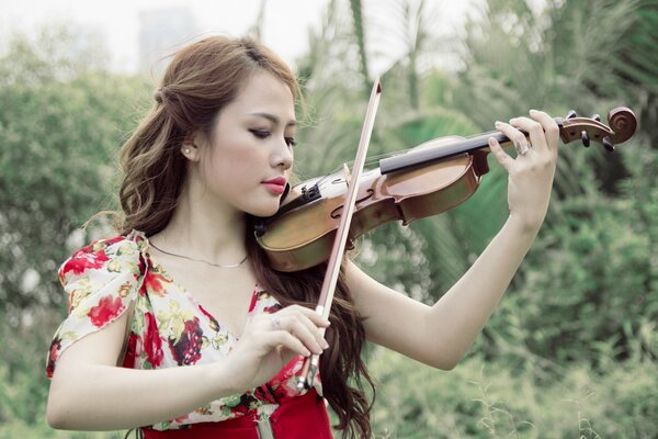 Chica asiática tocando el violín