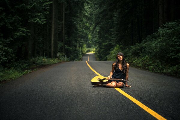 Fille avec une guitare sur la route