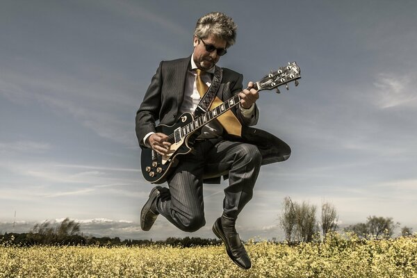 Un uomo con una chitarra in un campo