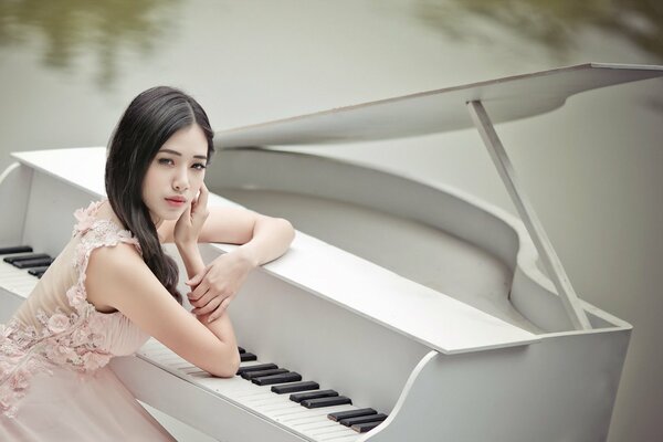 Asian girl sitting at the piano