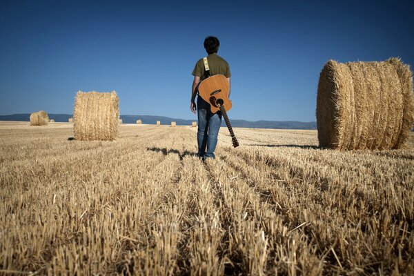 Mann mit Gitarre im Feld