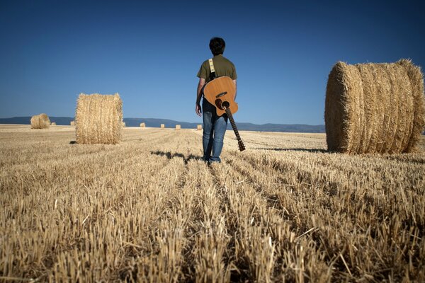 A man with a guitar in the field