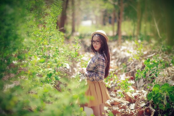 A girl in a hat in the forest in spring