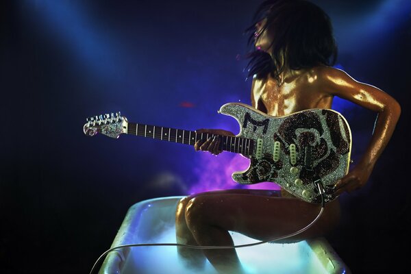 Chica con una guitarra en un vaso enorme