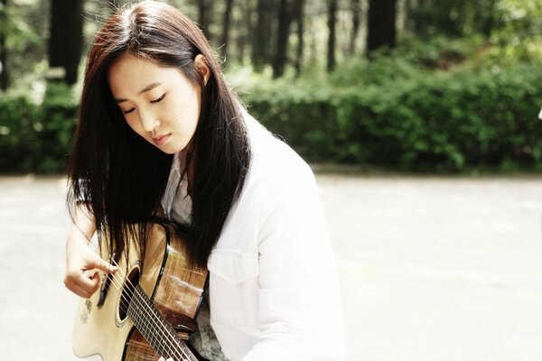 Foto de una cantante coreana con una guitarra