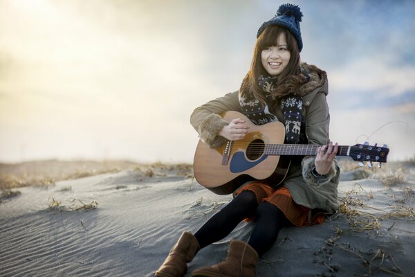 Ein Mädchen in einem Hut spielt Akustikgitarre