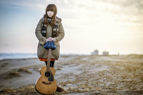 Chica con flequillo de pie sosteniendo la guitarra