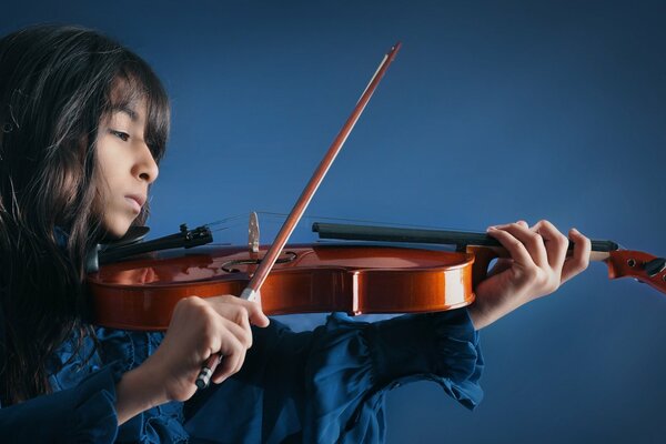 Fille jouant du violon sur fond bleu