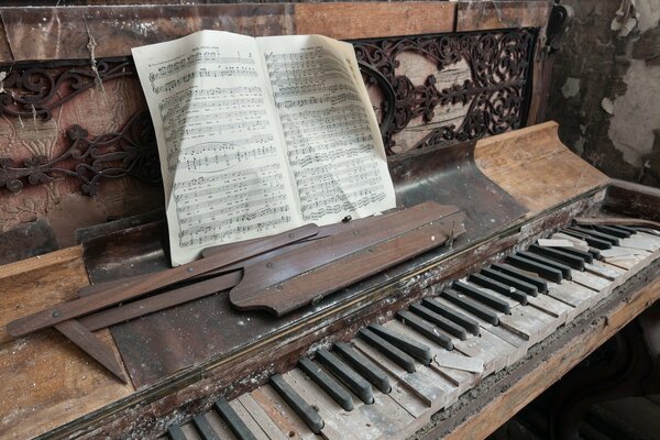 Un viejo piano polvoriento con un libro de notas