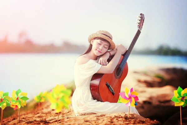 Chica con guitarra en la orilla