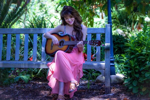 Bruna si siede su una panchina e suona la chitarra