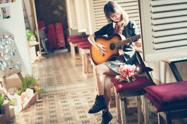 A little schoolgirl with a guitar in her hands