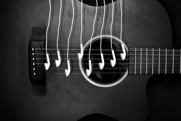 Guitarra negra con auriculares blancos