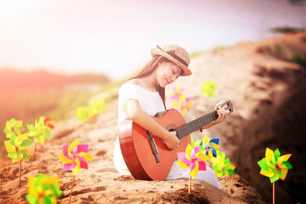 Chica con guitarra en la orilla del mar