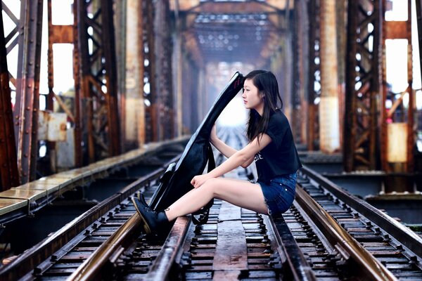 Chica sentada en las vías del tren