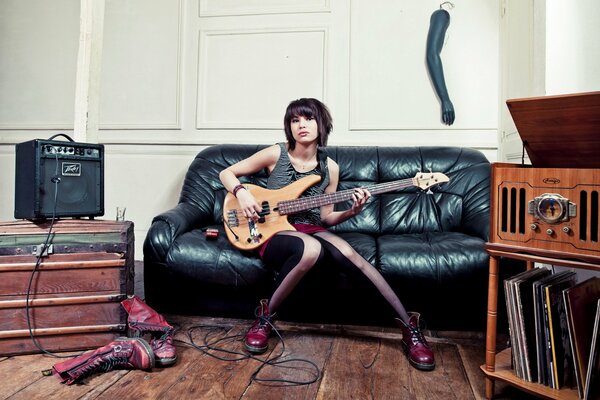 A girl with a guitar on the couch