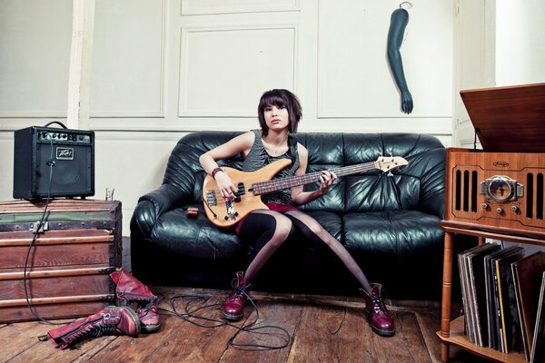 Chica con guitarra en el Sofá
