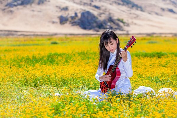 Chica con guitarra roja en el campo