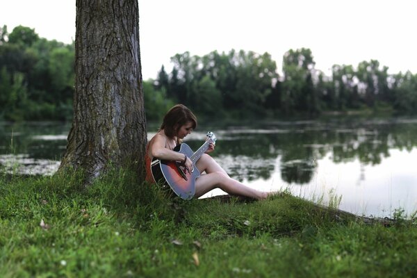 Chica con guitarra en el lago