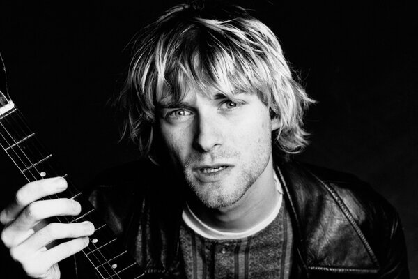 A man on a black background with a guitar