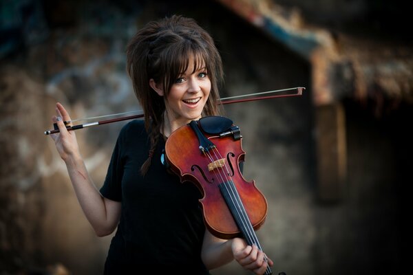 Piękna dziewczyna w czarnej sukience gra na skrzypcach